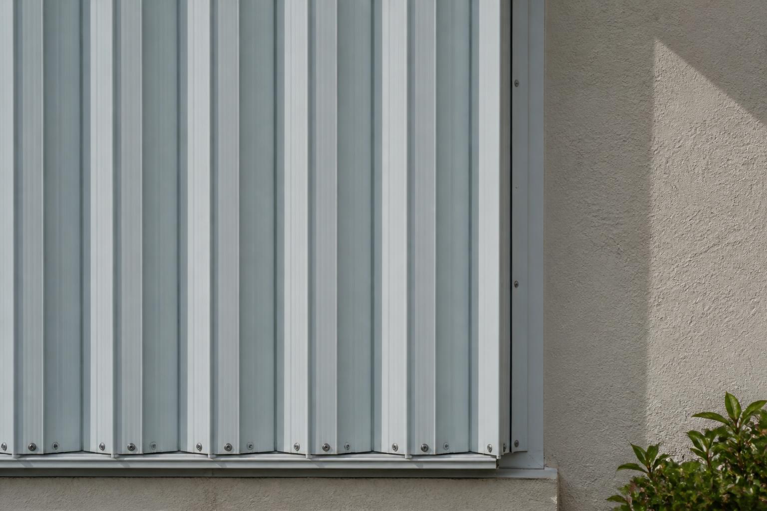 Close-up of hurricane window shutters mounted on the exterior wall of a Florida home