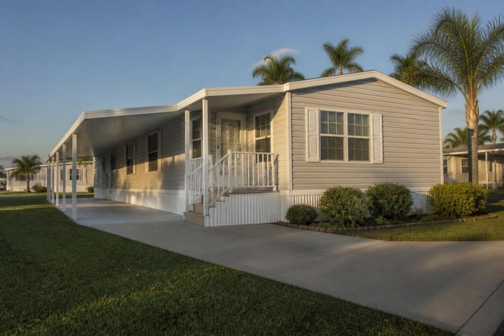 Manufactured home in a Florida community with palm trees and a covered carport